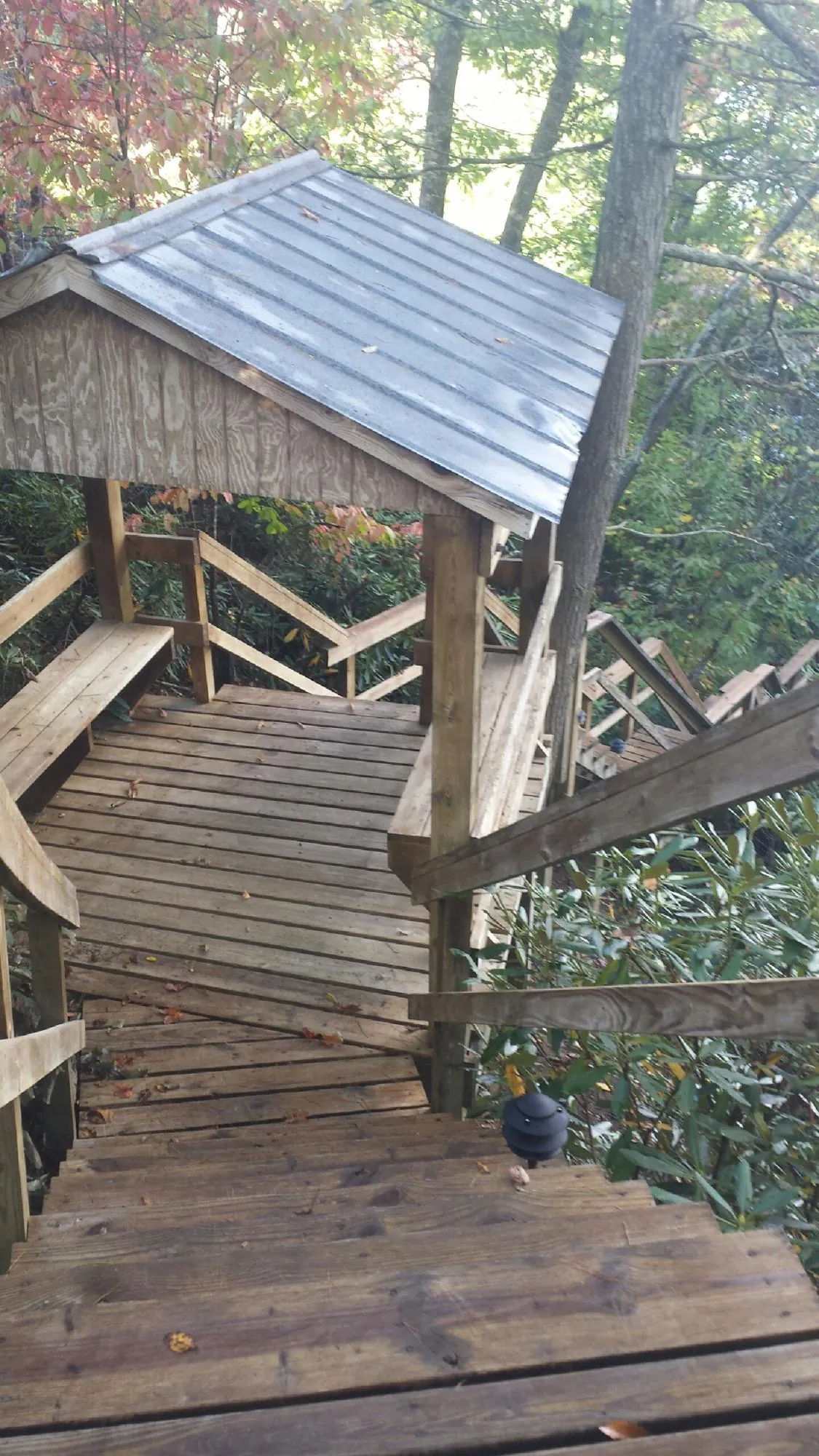 Metal roofed shelter over wooden steps on a wooded walkway — Skylight Repair & Installation work by our crew in Coulee Dam